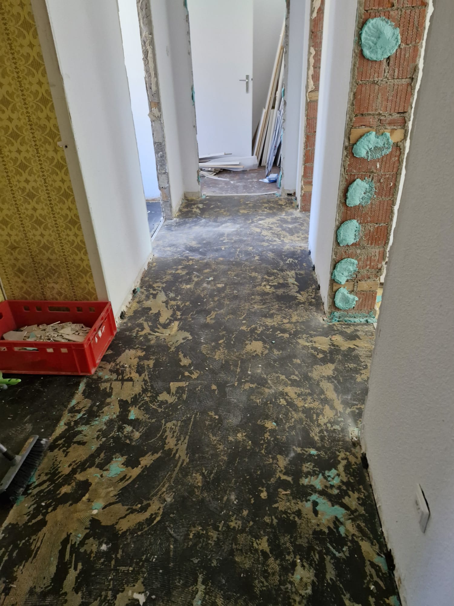 Flur vor der Renovierung: entkernt, freigelegte Mauerwerk und alter Boden